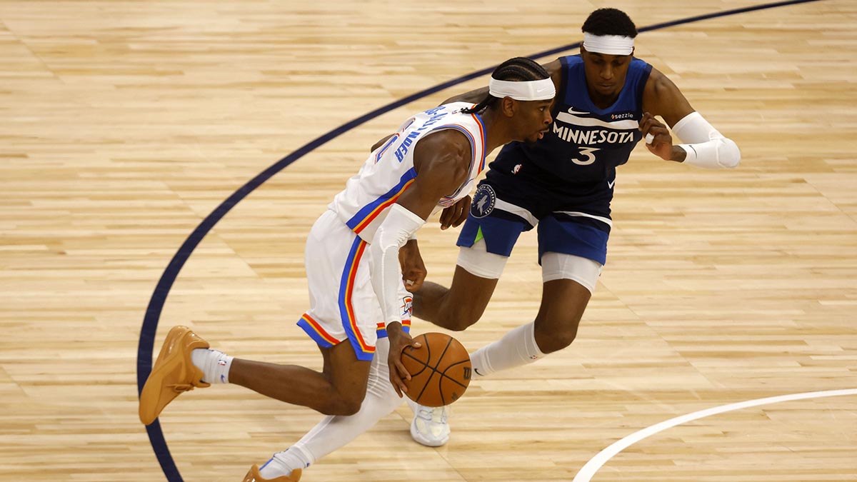 Oklahoma City Thunder guard Shai Gilgeous-Alexander (2) dribbles the ball past Minnesota Timberwolves forward Jaden McDaniels (3) in the first half during game four of the western conference finals for the 2025 NBA Playoffs at Target Center.