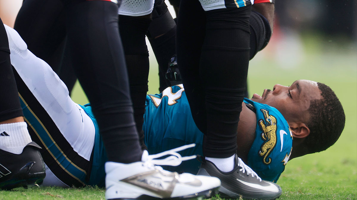 Jacksonville Jaguars defensive end Travon Walker (44) gets up off the turf after losing his helmet during the first quarter of an NFL football matchup at EverBank Stadium.