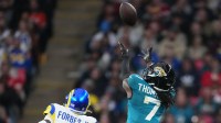 Jacksonville Jaguars wide receiver Brian Thomas Jr. (7) reaches for the ball against Los Angeles Rams cornerback Emmanuel Forbes Jr. (1) during the second half of an NFL International Series game at Wembley Stadium.