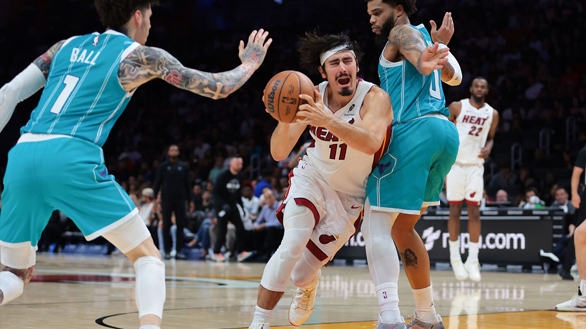 Miami Heat guard Jaime Jaquez Jr. (11) drives to the basket against Charlotte Hornets forward Miles Bridges (0) and guard Lamelo Ball (1) during the third quarter at Kaseya Center.