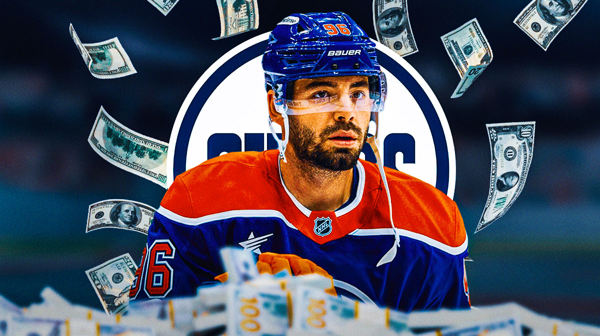 Jake Walman with money around him and the Oilers logo in the background.
