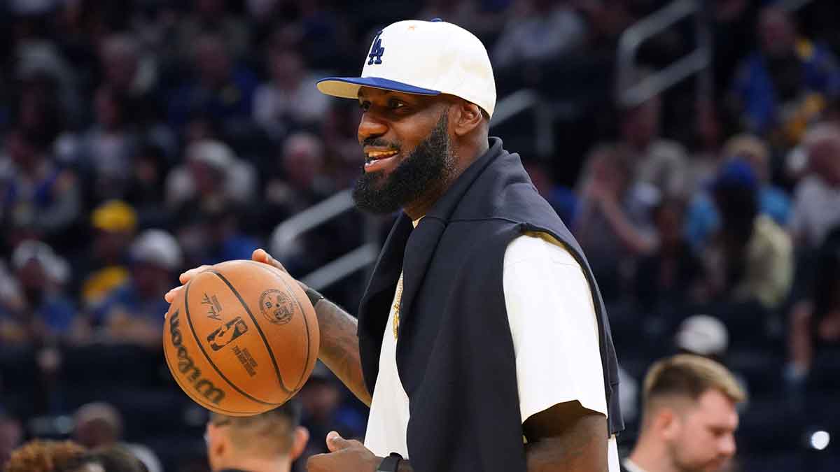 Los Angeles Lakers forward LeBron James (23), wearing a Los Angeles Dodgers hat, watches from the sideline during a break against the Golden State Warriors in the third quarter at Chase Center