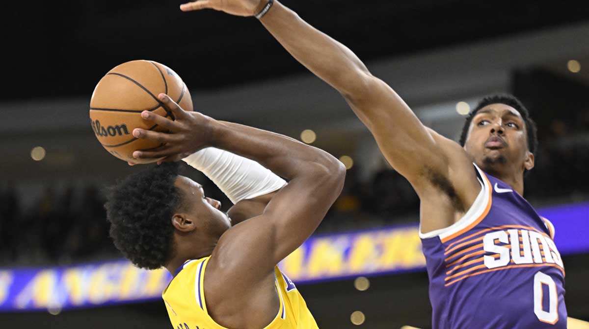 Los Angeles Lakers guard Bronny James (9) tries to shoot past Phoenix Suns forward Ryan Dunn (0) during the first half at Acrisure Arena.