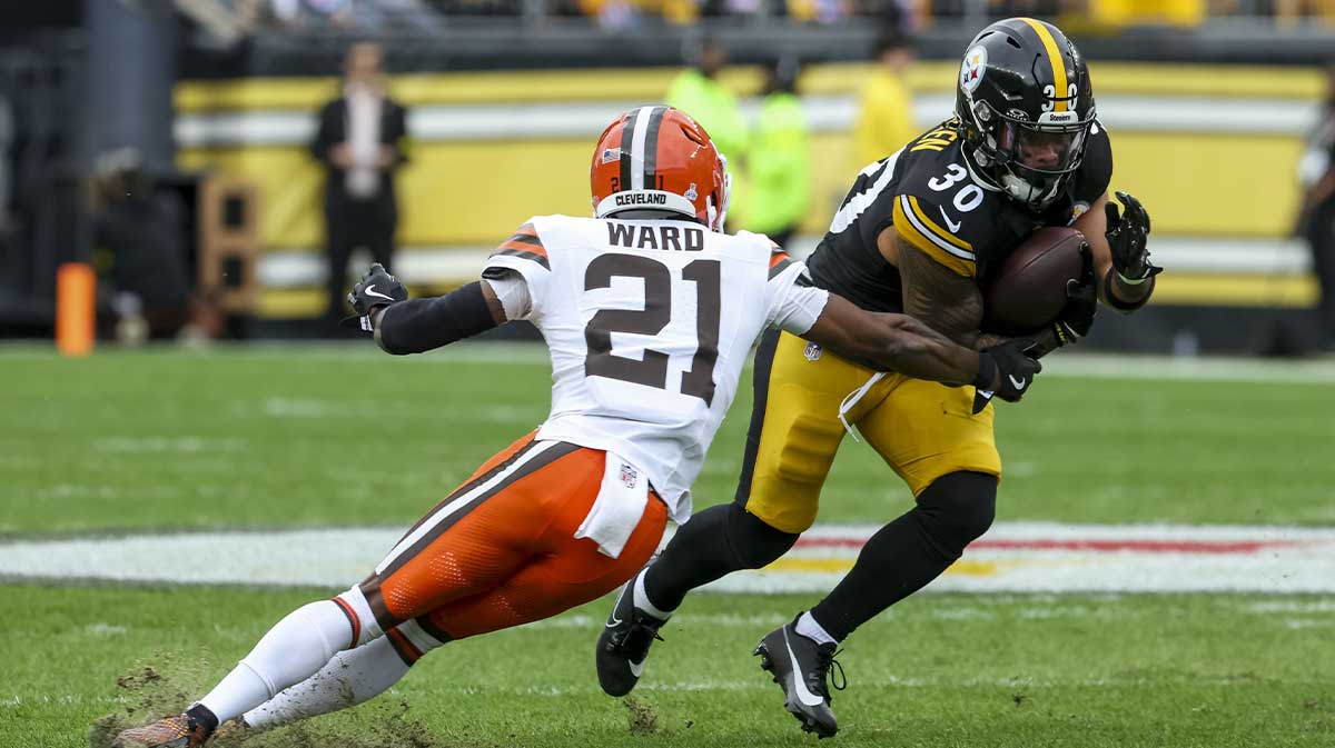 Pittsburgh Steelers running back Jaylen Warren (30) runs the ball while Cleveland Browns cornerback Denzel Ward (21) defends during the first quarter at Acrisure Stadium