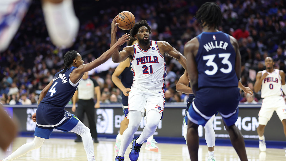Philadelphia 76ers center Joel Embiid (21) drives the lane between Minnesota Timberwolves guard Rob Dillingham (4) and forward Leonard Miller (33) during the third quarter at Xfinity Mobile Arena.