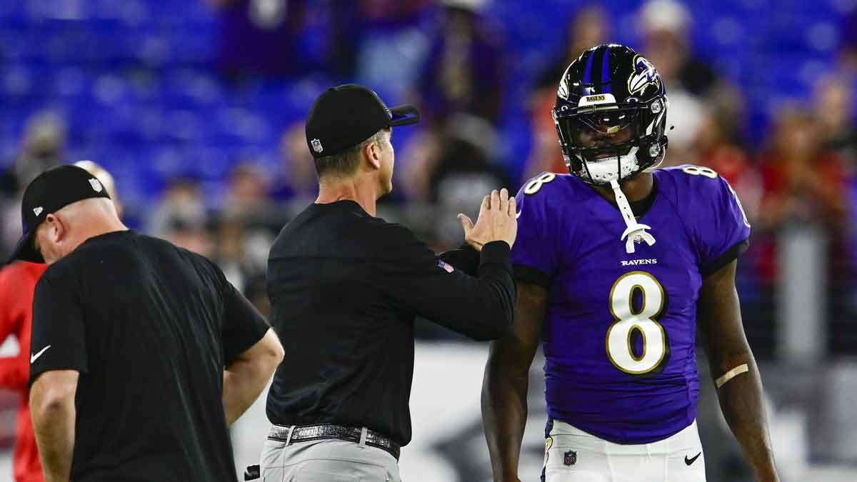 Baltimore Ravens head coach John Harbaugh speaks with quarterback Lamar Jackson (8) before the game against the Kansas City Chiefs at M&T Bank Stadium.