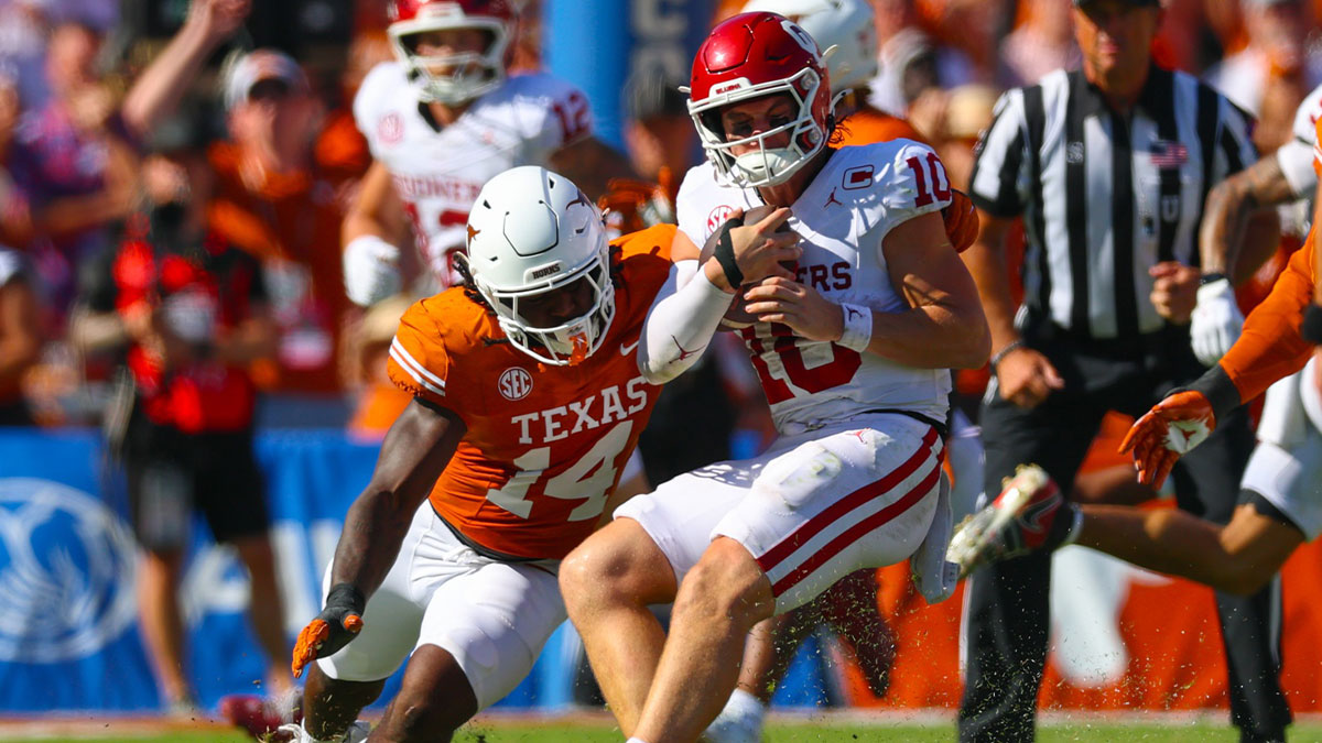 Texas Longhorns linebacker Brad Spence (14) looks to tackle Oklahoma Sooners quarterback John Mateer (10) during the first half at the Cotton Bowl.