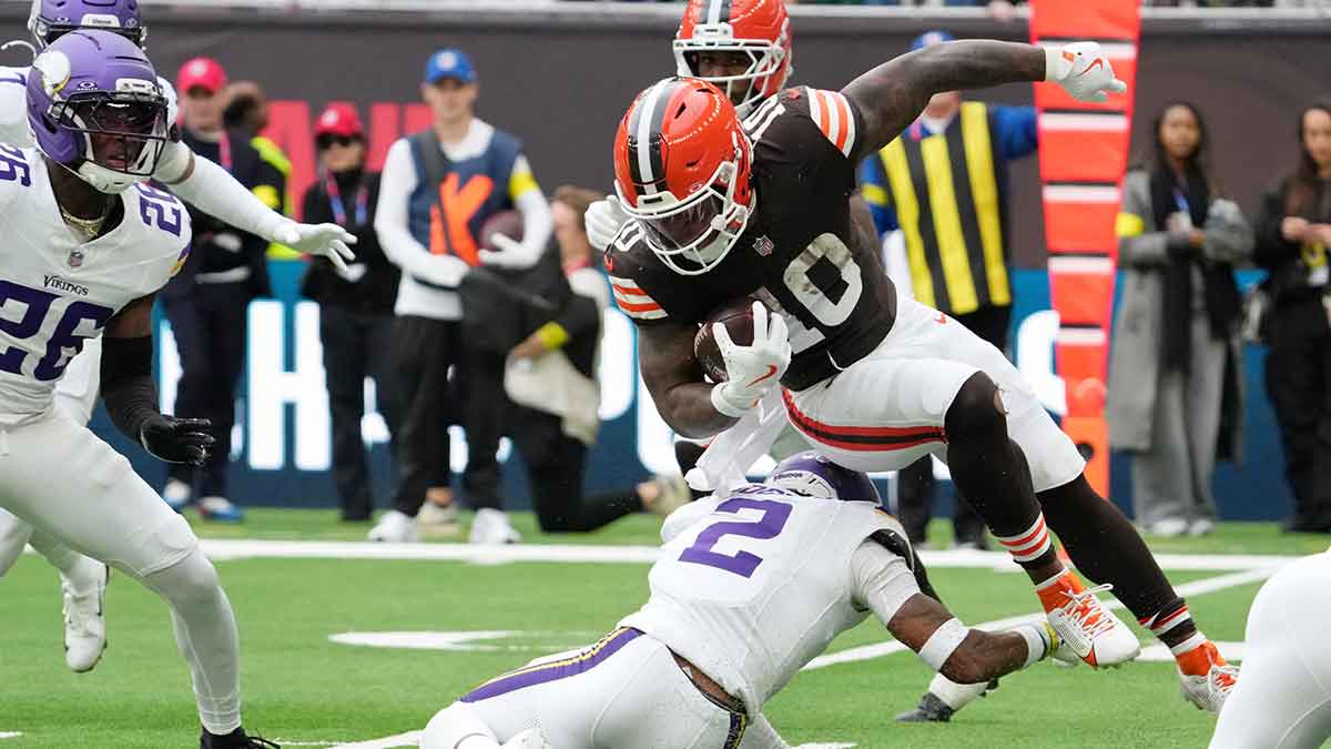 Cleveland Browns running back Quinshon Judkins (10) gets tripped up against Minnesota Vikings cornerback Isaiah Rodgers (2) during the third quarter of an NFL International Series game at Tottenham Hotspur Stadium.