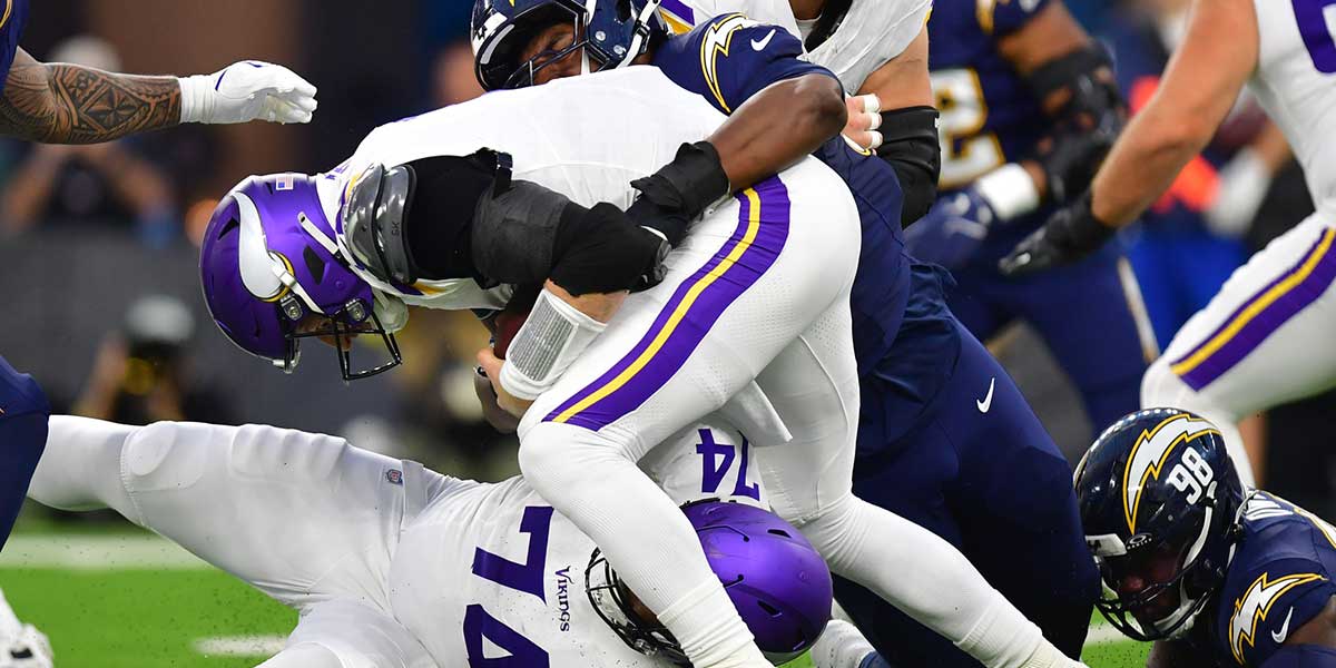 Los Angeles Chargers defensive tackle Justin Eboigbe (92) tackles Minnesota Vikings quarterback Carson Wentz (11) during the first half at SoFi Stadium.