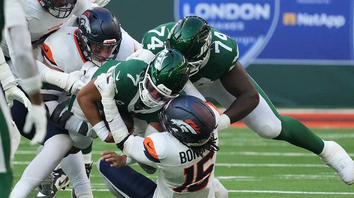 New York Jets quarterback Justin Fields (7) is tackled by Denver Broncos linebacker Nik Bonitto (15) during an NFL International Series game at Tottenham Hotspur Stadium. 