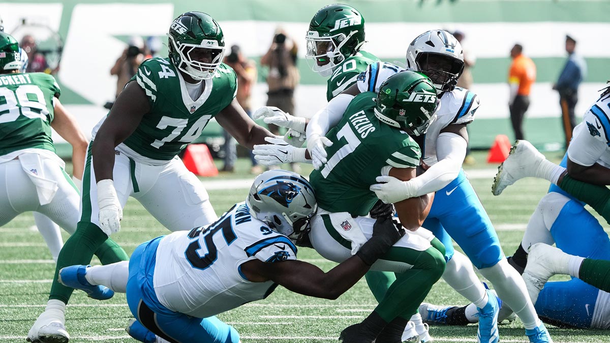 New York Jets quarterback Justin Fields (7) is brought down by Carolina Panthers defensive end Derrick Brown (95) and outside linebacker Nic Scourton (11) at MetLife Stadium.