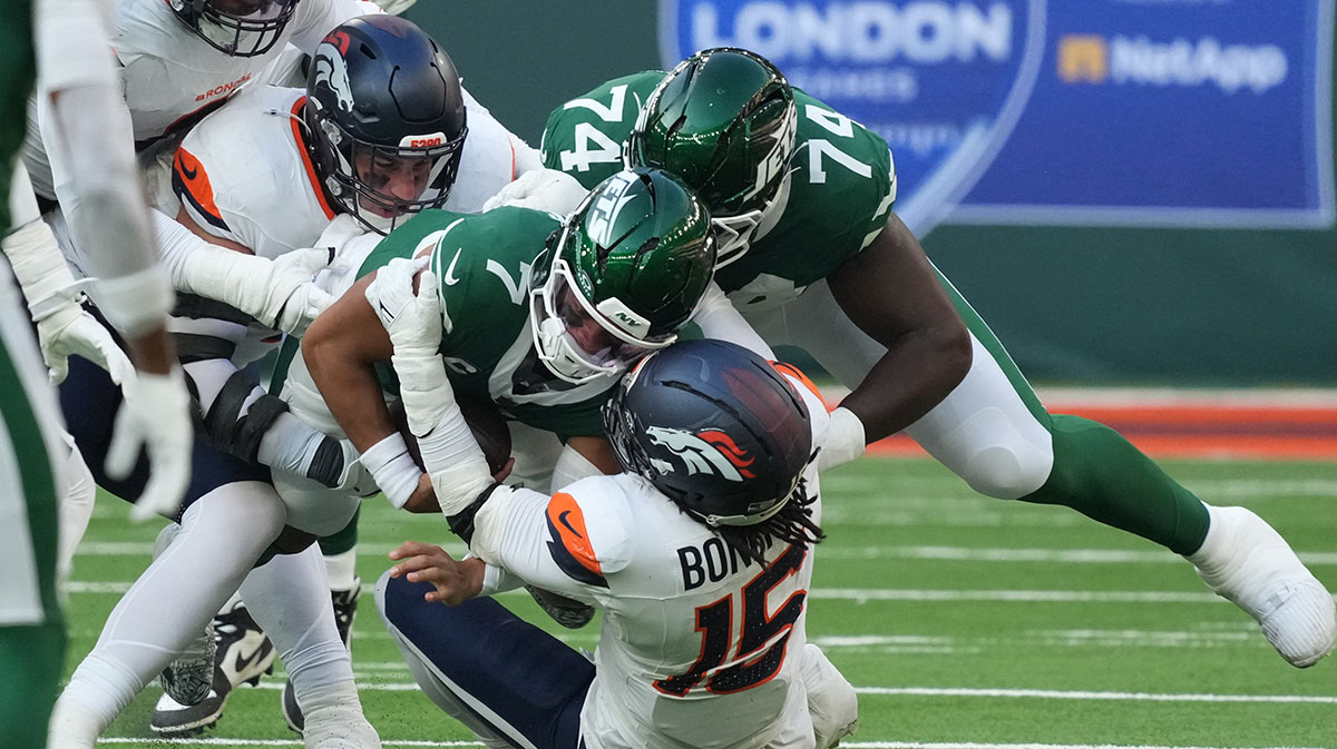 New York Jets quarterback Justin Fields (7) is tackled by Denver Broncos linebacker Nik Bonitto (15) during an NFL International Series game at Tottenham Hotspur Stadium.