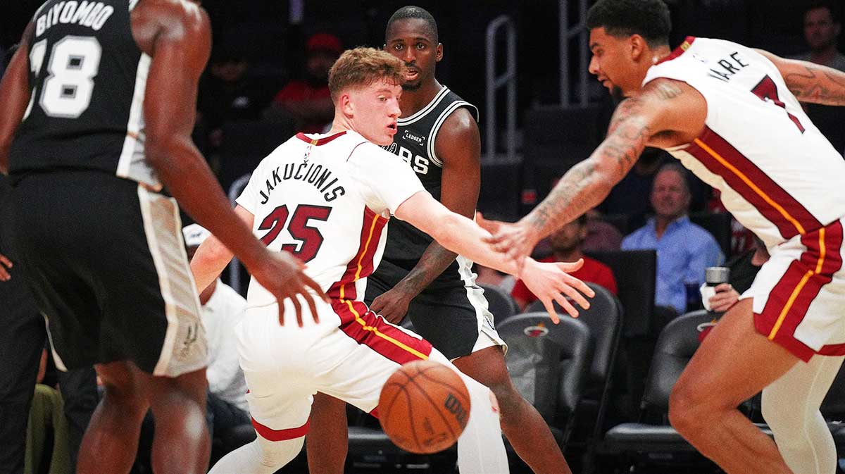 San Antonio Spurs forward David Jones Garcia (25) threads a pass to center Bismack Biyombo (18) as Miami Heat guard Kasparas Jakucionis (25) and center Kel'El Ware (7) defend during the second half at Kaseya Center.