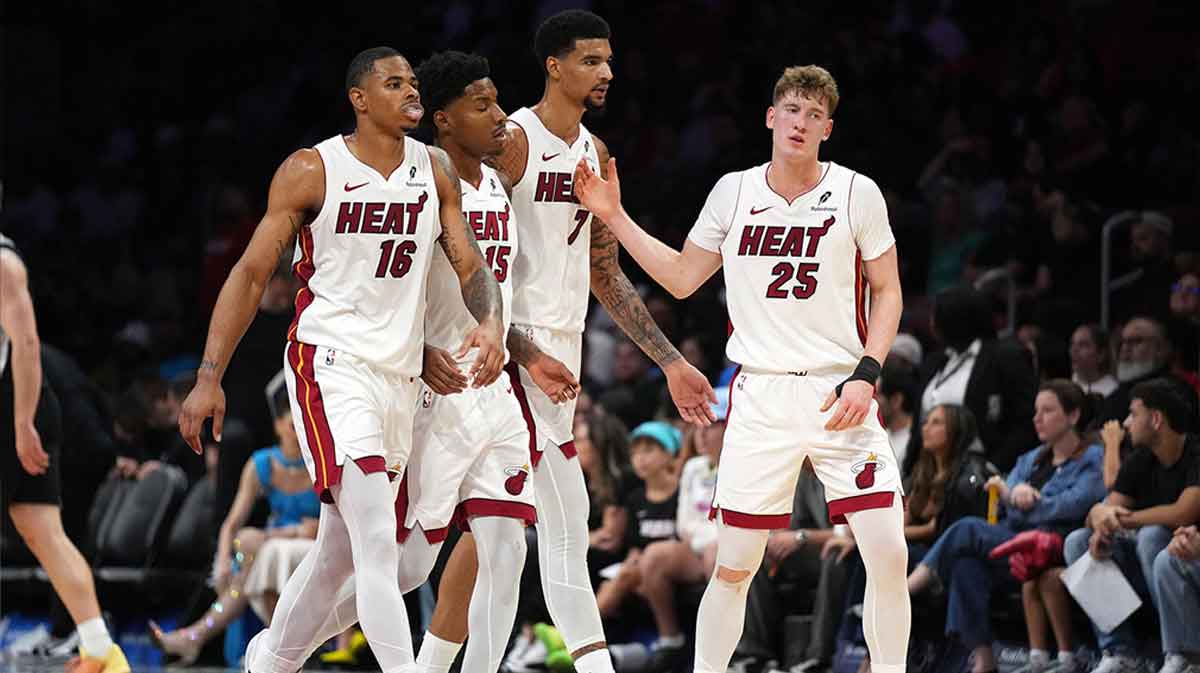 Miami Heat guard Kasparas Jakucionis (25) is congratulated by forward Keshad Johnson (16), forward Myron Gardner (15) and center Kel'El Ware (7) during a timeout in the second half against the San Antonio Spurs at Kaseya Center.