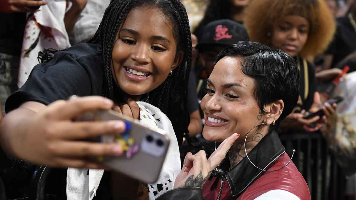 Oct 8, 2023; Las Vegas, Nevada, USA; Singer Kehlani takes a photo with a fan after game one of the 2023 WNBA Finals between the Las Vegas Aces and the New York Liberty at Michelob Ultra Arena. Mandatory Credit: