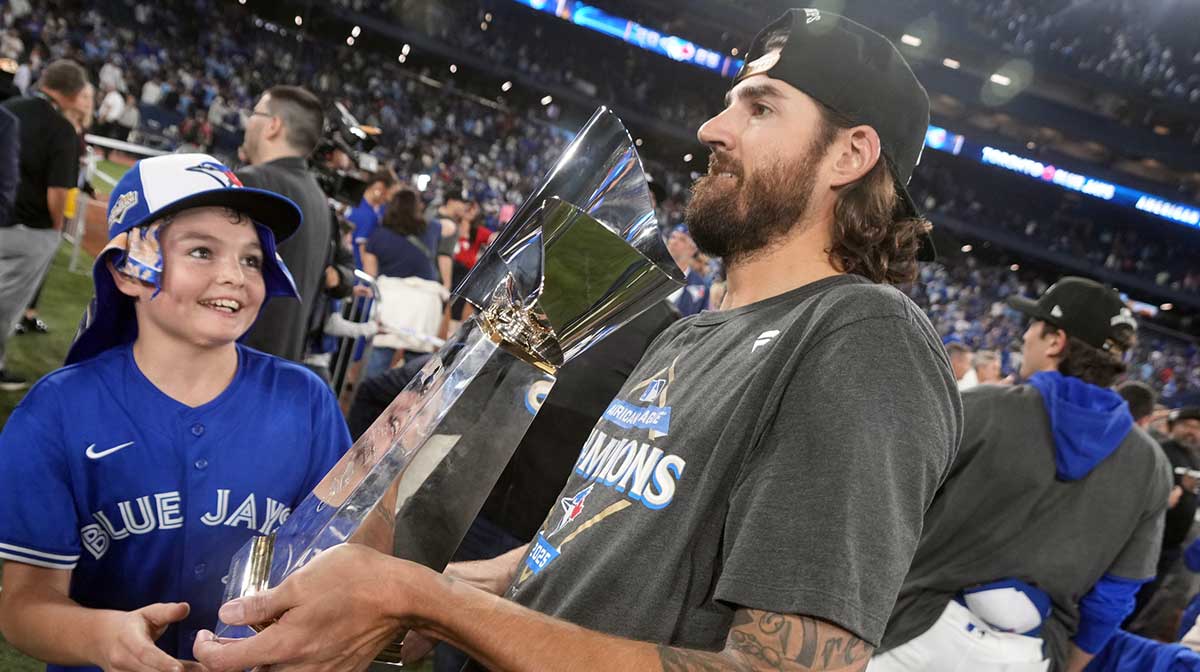 Toronto Blue Jays pitcher Kevin Gausman (34) celebrates with the trophy on the field after defeating the Seattle Mariners in game seven of the ALCS round for the 2025 MLB playoffs at Rogers Centre.