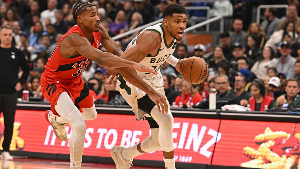 Milwaukee Bucks forward Giannis Antetokounmpo (34) dribbles past Toronto Raptors guard Ochai Agbaji (30) in the second quarter at Scotiabank Arena.