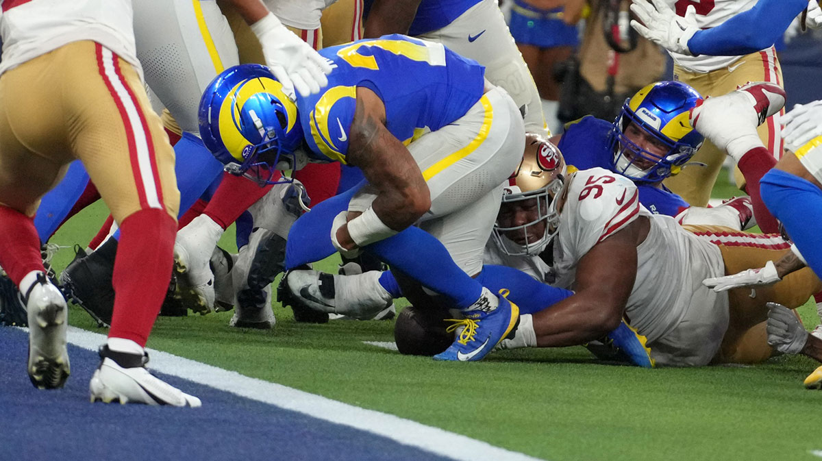 San Francisco 49ers defensive tackle Alfred Collins (95) forces a fumble by Los Angeles Rams running back Kyren Williams (23) at the 1-yard line in the fourth quarter at SoFi Stadium.