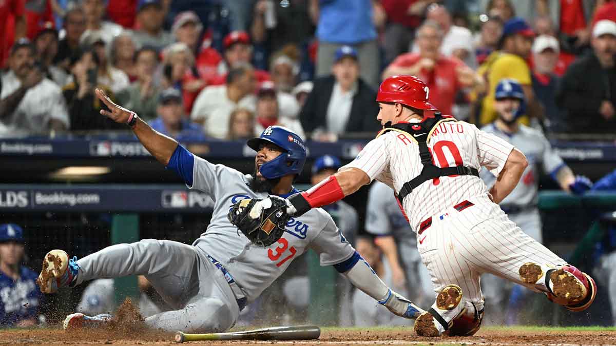 Los Angeles Dodgers right fielder Teoscar Hernandez (37) slides safely into home plate against Philadelphia Phillies catcher J.T. Realmuto (10) in the seventh inning during game two of the NLDS round for the 2025 MLB playoffs at Citizens Bank Park.