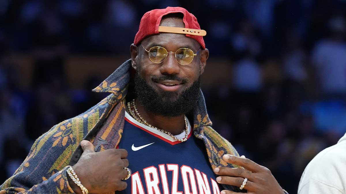 Lakers forward LeBron James poses in the Arizona Wildcats jersey of his son Bryce James (6) during the game against the Minnesota Timberwolves at Crypto.com Arena with Charles Barkley in the background