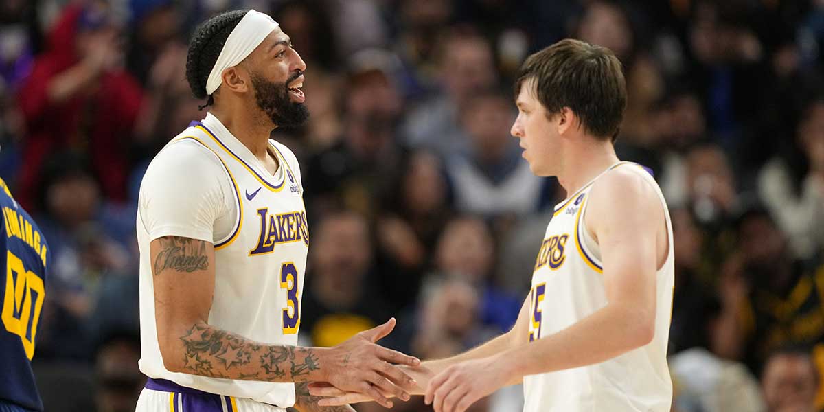 Lakers forward Anthony Davis (3) celebrates with guard Austin Reaves (right) during the fourth quarter against the Golden State Warriors at Chase Center with Luka Doncic in the background