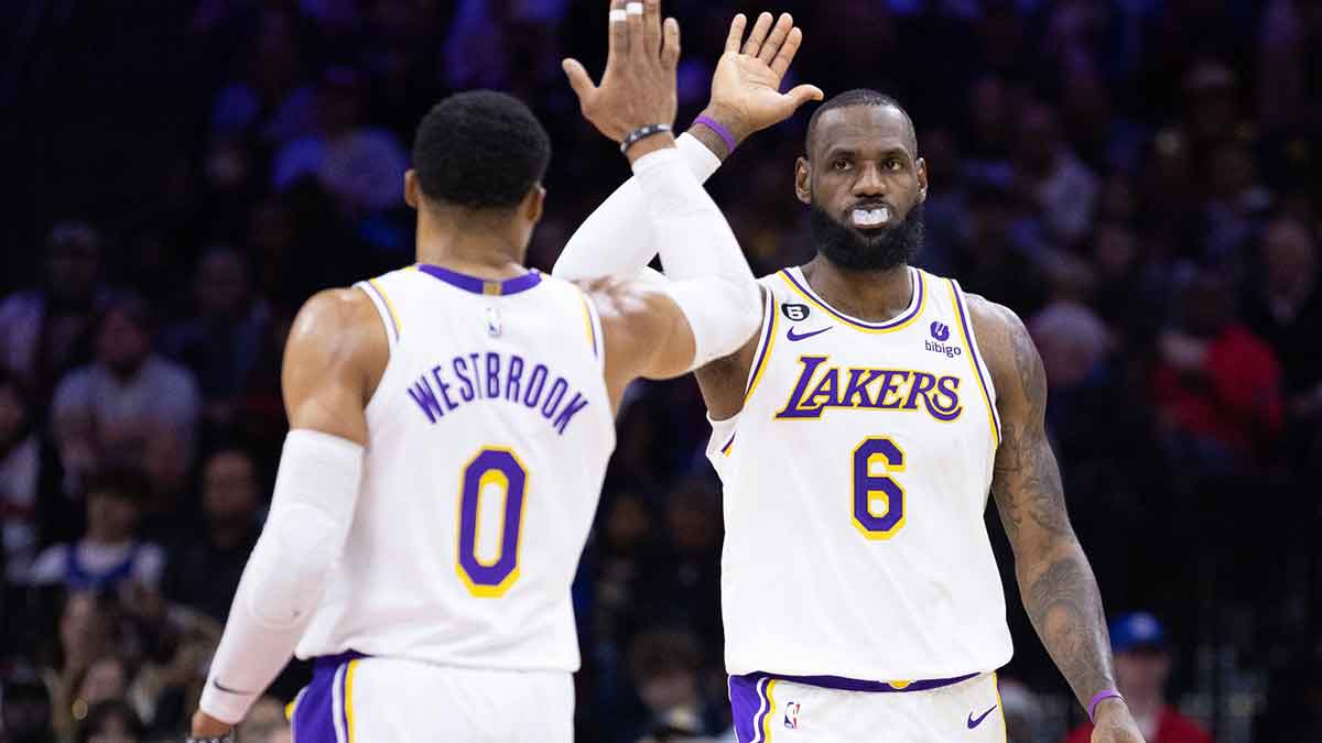 Lakers forward LeBron James (6) and guard Russell Westbrook (0) high five after a score against the Philadelphia 76ers during the second quarter at Wells Fargo Center with Kyrie Irving in the background