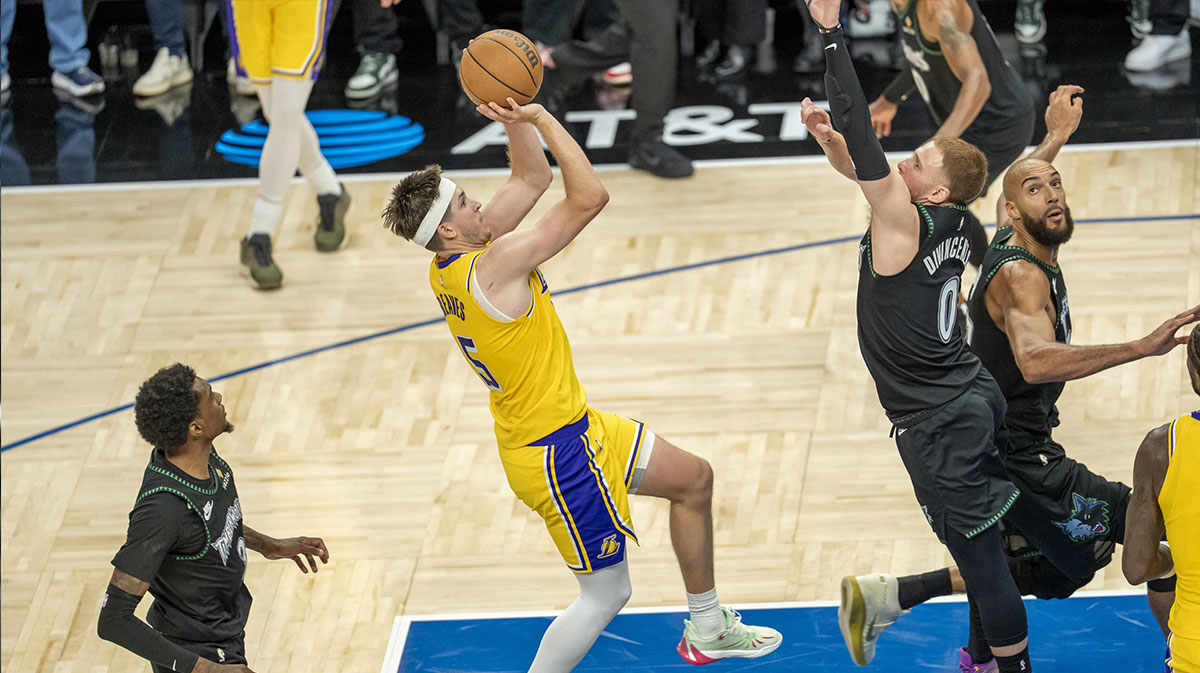Los Angeles Lakers guard Austin Reaves (15) shoots a game winning shot over Minnesota Timberwolves guard Donte DiVincenzo (0) in the second half at Target Center. Mandatory Credit: Jesse Johnson-Imagn Images