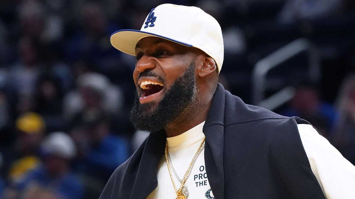 Los Angeles Lakers forward LeBron James (23), wearing a Los Angeles Dodgers hat, watches from the sideline during a break against the Golden State Warriors in the third quarter at Chase Center.