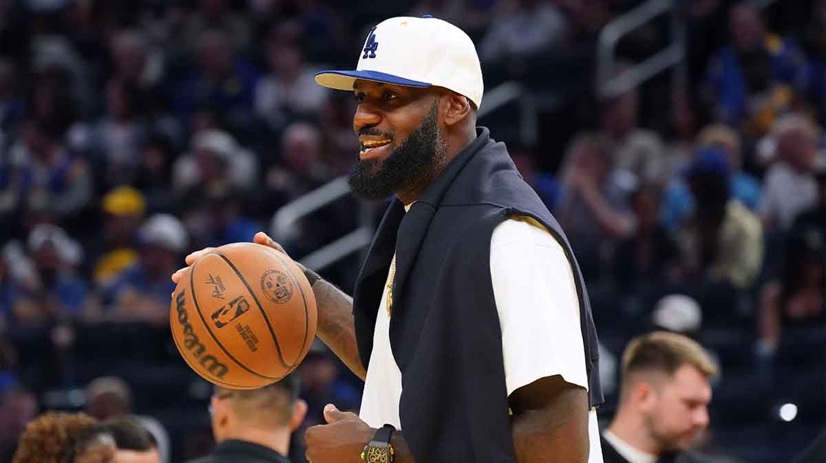 Los Angeles Lakers forward LeBron James (23), wearing a Los Angeles Dodgers hat, watches from the sideline during a break against the Golden State Warriors in the third quarter at Chase Center.