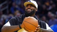 Los Angeles Lakers forward LeBron James (23), wearing a Los Angeles Dodgers hat, watches from the sideline during a break against the Golden State Warriors in the third quarter at Chase Center.