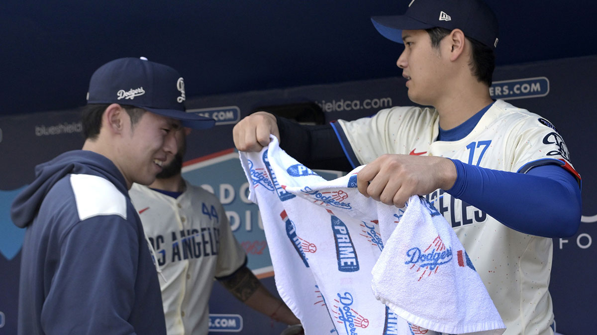Los Angeles Dodgers designated hitter Shohei Ohtani (17) puts a towel over the head of starting pitcher Roki Sasaki (11) in the dugout prior to the game against the New York Yankees at Dodger Stadium.