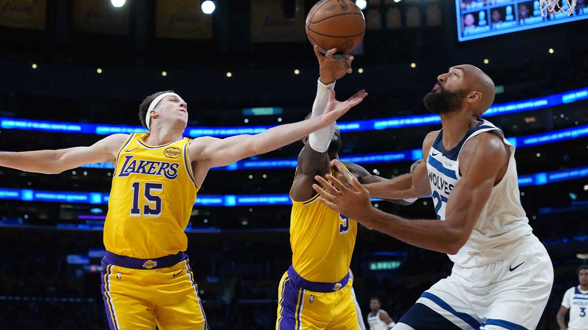 Los Angeles Lakers guard Austin Reaves (15) and center Deandre Ayton (5) battle for the ball with Minnesota Timberwolves center Rudy Gobert (27) in the first half at Crypto.com Arena.