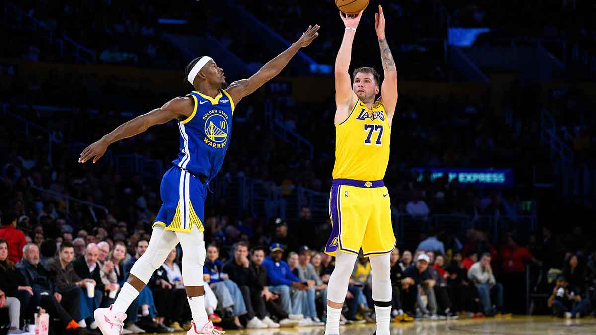 Oct 21, 2025; Los Angeles, California, USA; Los Angeles Lakers guard Luka Doncic (77) shoots over Golden State Warriors forward Jimmy Butler III (10) during the first half at Crypto.com Arena. Mandatory Credit: William Liang-Imagn Images