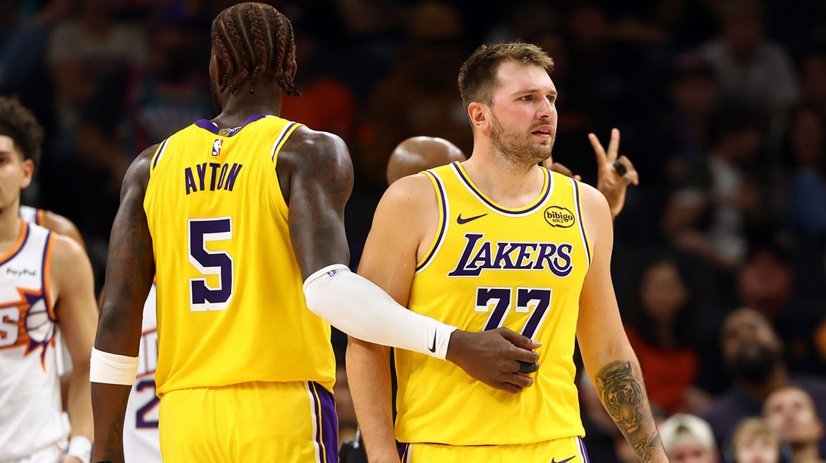Phoenix, Arizona, USA; Los Angeles Lakers guard Luka Doncic (77) with center Deandre Ayton (5) against the Phoenix Suns during an NBA preseason game at Mortgage Matchup Center.