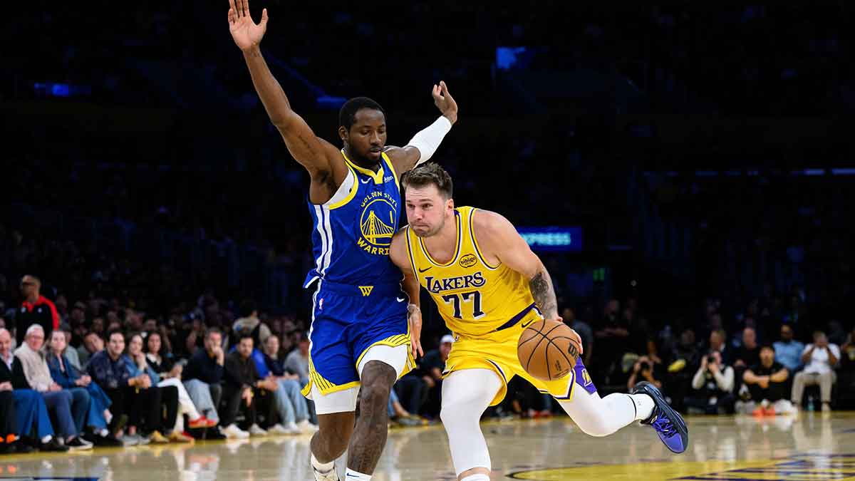 Los Angeles Lakers guard Luka Doncic (77) drives past Golden State Warriors forward Jonathan Kuminga (1) during the first half at Crypto.com Arena.