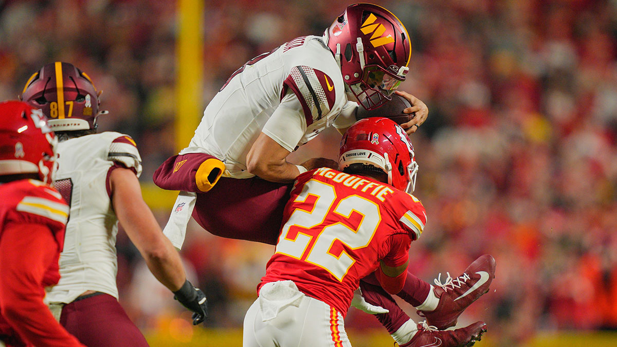 Kansas City Chiefs cornerback Trent McDuffie (22) tackles Washington Commanders quarterback Marcus Mariota (8) during the second quarter of the game at GEHA Field at Arrowhead Stadium.