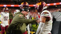 Washington Commanders head coach Dan Quinn celebrates an interception against the Kansas City Chiefs with Washington Commanders cornerback Marshon Lattimore (2) during the first quarter of the game at GEHA Field at Arrowhead Stadium.