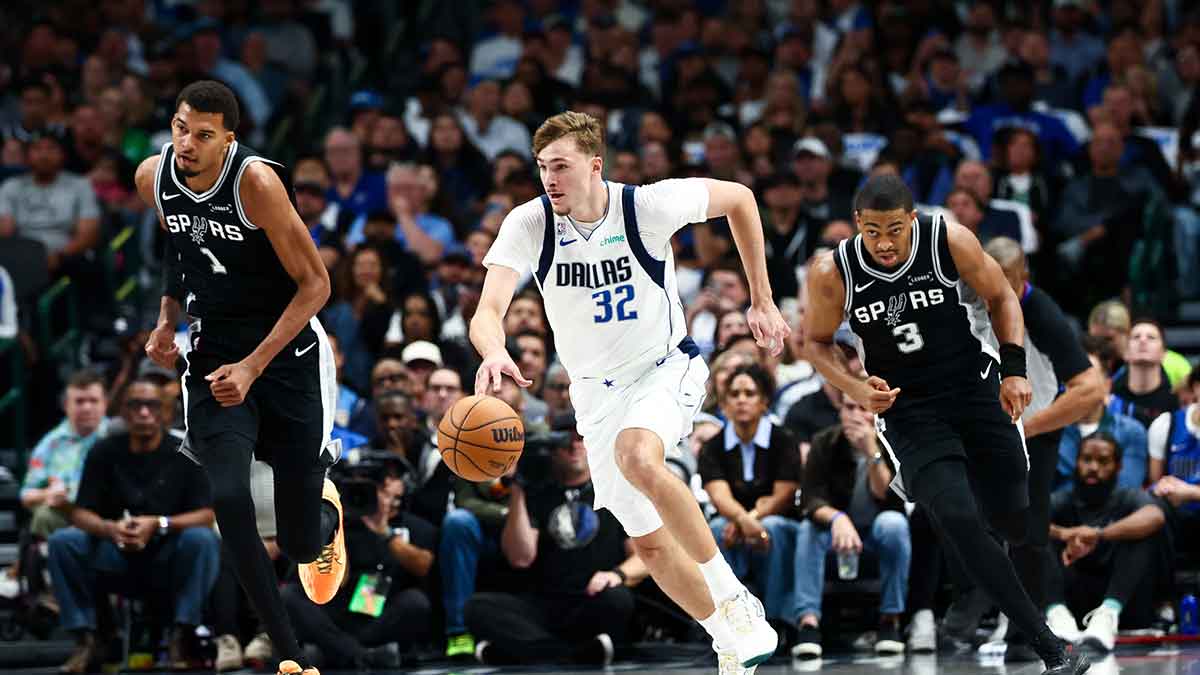 Dallas Mavericks forward Cooper Flagg (32) dribbles the ball as San Antonio Spurs forward Victor Wembanyama (1) and San Antonio Spurs forward Keldon Johnson (3) chase during the first half at American Airlines Center.