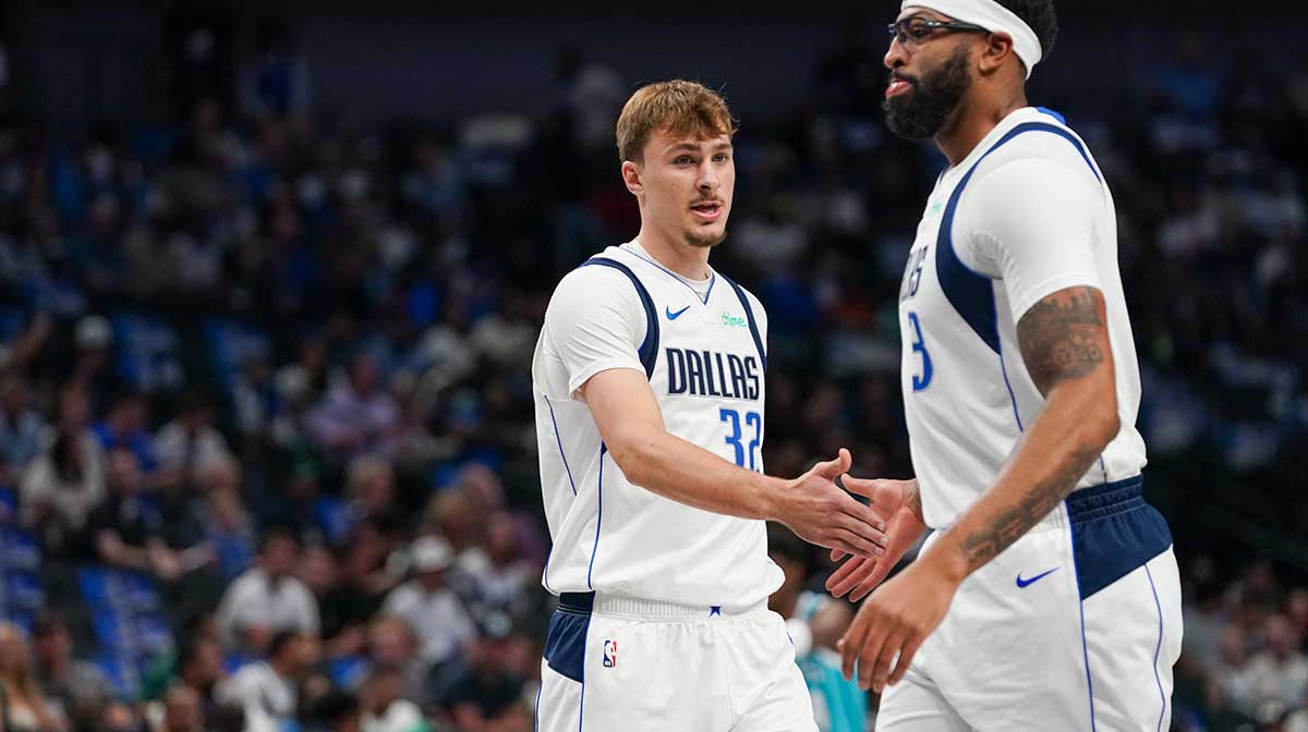 Mavericks forward Cooper Flagg (32) low fives forward/center Anthony Davis (3) in the first half of game against the Charlotte Hornets at American Airlines Center