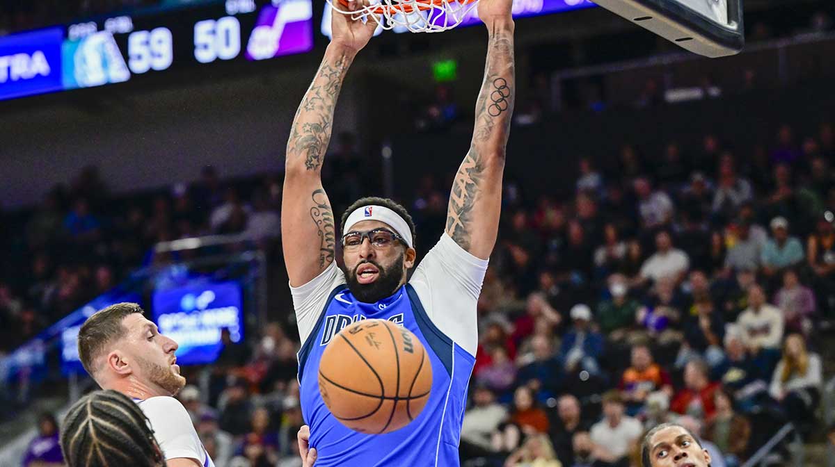 Mavericks forward/center Anthony Davis (3) makes a slam dunk over Utah Jazz center Jusuf Nurkić (30) during the second quarter at Delta Center with Mavericks head coach Jason Kidd and the Lakers logo in the background