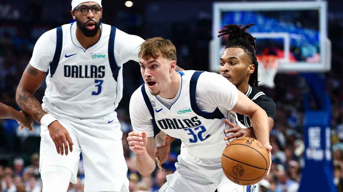 Dallas Mavericks forward Cooper Flagg (32) dribbles as San Antonio Spurs guard Stephon Castle (5) defends during the first quarter at American Airlines Center.