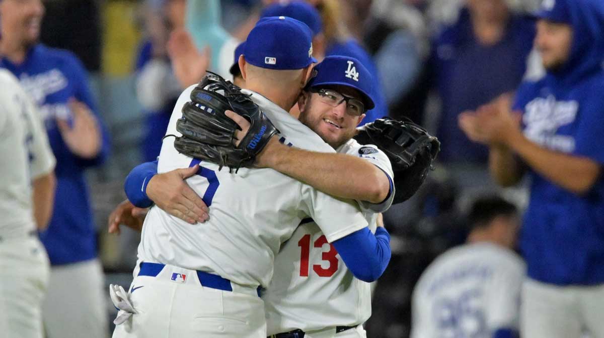 Los Angeles Dodgers first baseman Freddie Freeman (5) and third baseman Max Muncy (13) embrace after the final out of game five of the NLCS in the 2025 MLB playoffs defeating the Milwaukee Brewers at Dodger Stadium.