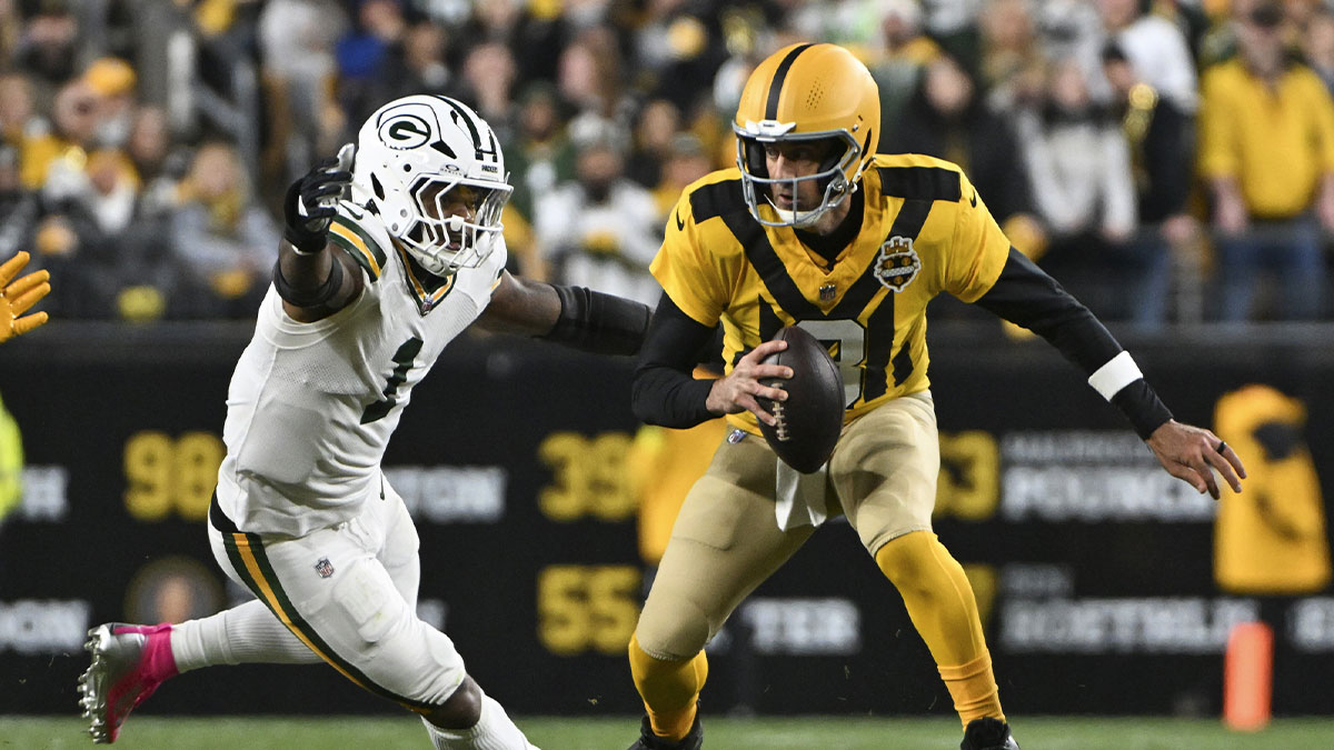 Pittsburgh Steelers quarterback Aaron Rodgers (8) scrambles against Green Bay Packers defensive end Micah Parsons (1) during the first quarter at Acrisure Stadium.