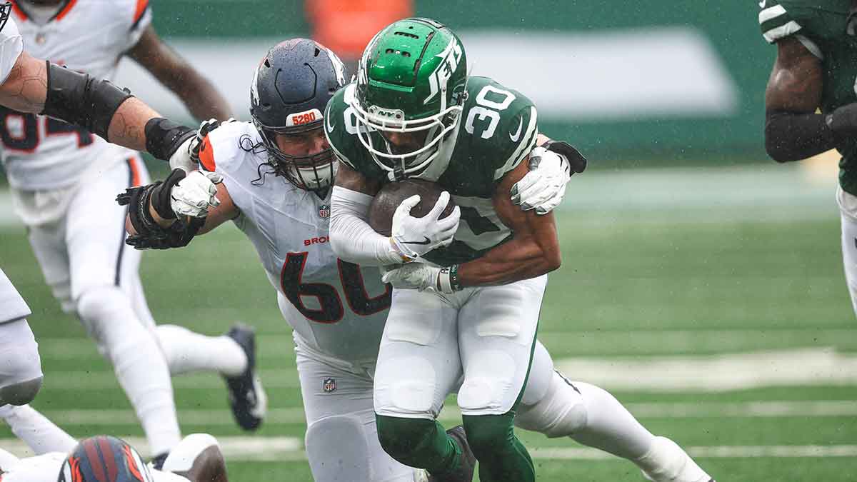 New York Jets cornerback Michael Carter II (30) is tackled by Denver Broncos center Luke Wattenberg (60) after recovering a fumble during the first half at MetLife Stadium.