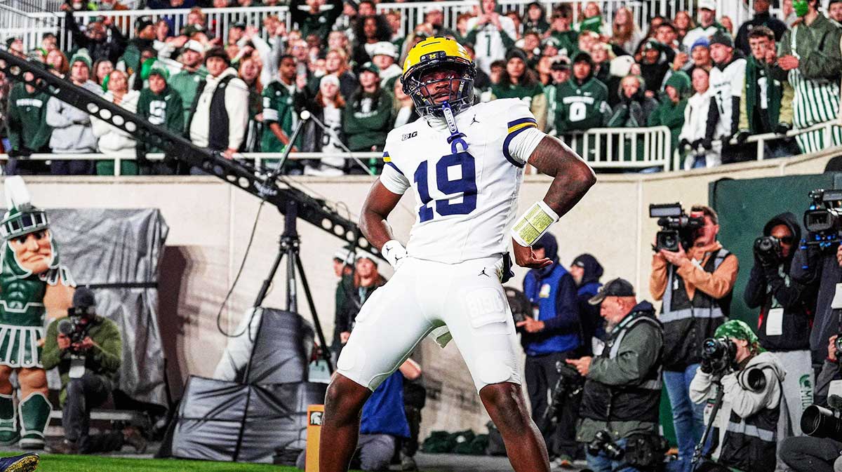 Michigan quarterback Bryce Underwood celebrates a touchdown by posing as the Paul Bunyan Trophy against Michigan State during the first half at Spartan Stadium in East Lansing on Saturday, October 25, 2025.