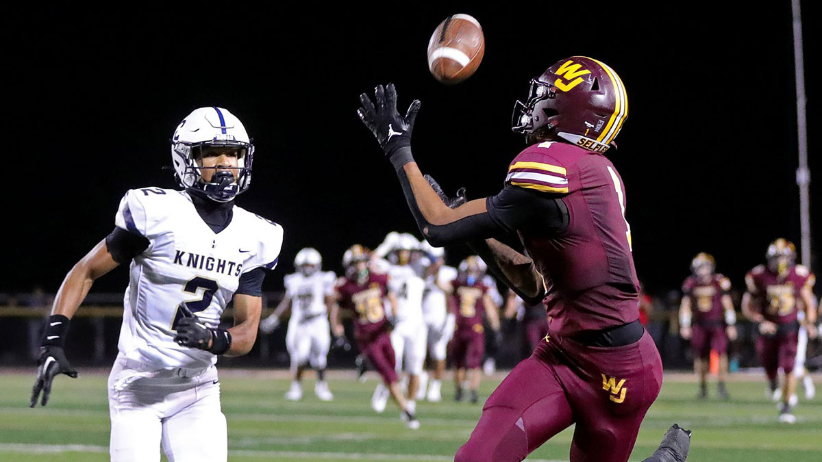 Walsh Jesuit wide receiver Milan Parris catches a pass for a first down as Hoban defensive back John Johnson tries to defend.