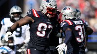 New England Patriots defensive end Milton Williams (97) and safety Craig Woodson (31) react after making at tackle against the Carolina Panthers during the first half at Gillette Stadium.