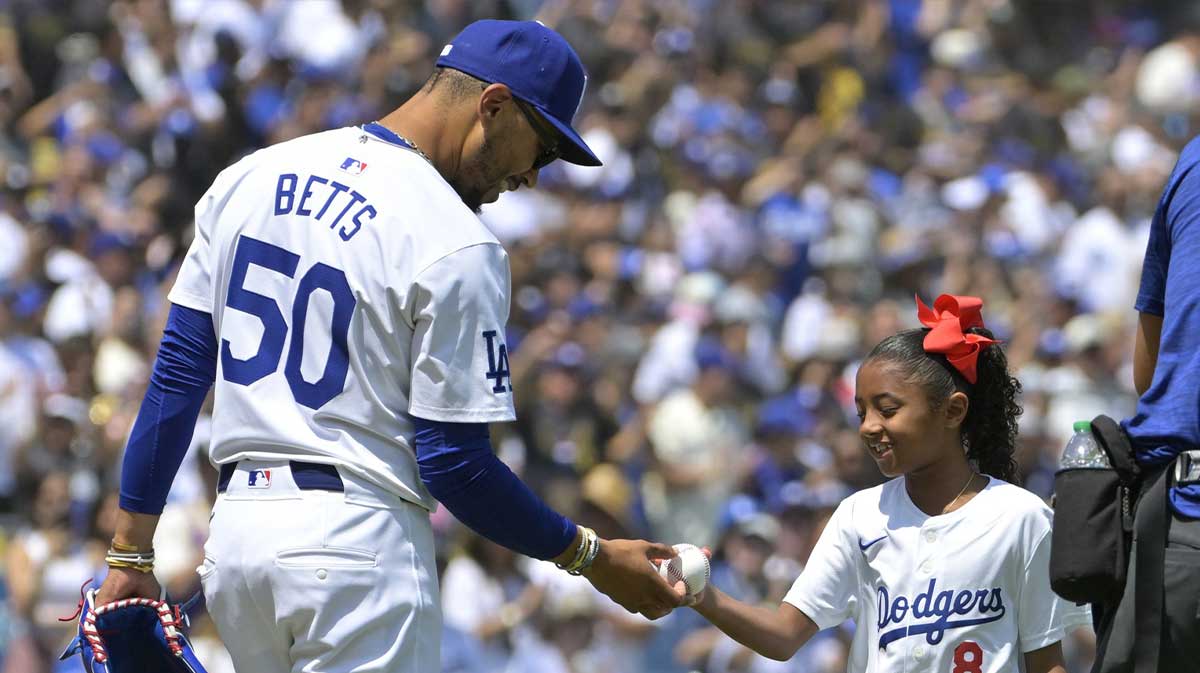 Los Angeles Dodgers shortstop Mookie Betts (50) hands the ball to Los Angeles Lakers Kobe Bryant’s daughter Bianka, 7, after throwing out the first pitch prior to the game against the Tampa Bay Rays.