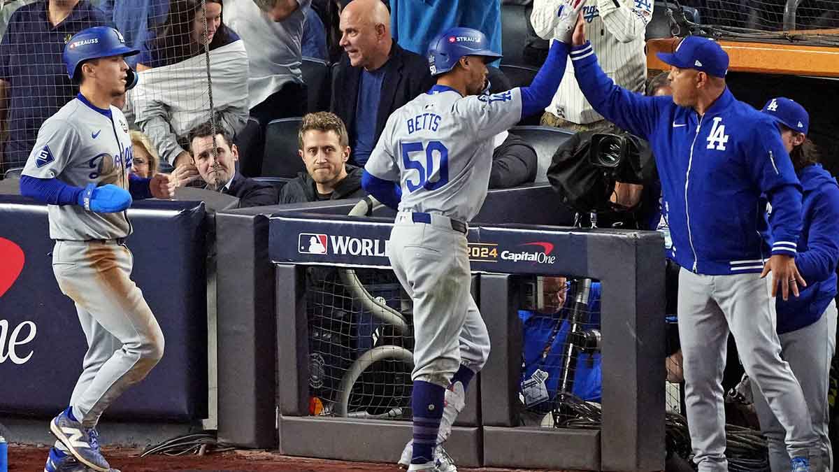 Los Angeles Dodgers manager Dave Roberts (30) celebrates with shortstop Mookie Betts (50) after he hit a sacrifice fly during the eighth inning against the New York Yankees in game four of the 2024 MLB World Series at Yankee Stadium.