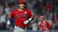 Los Angeles Angels catcher Kurt Suzuki (24) runs to first after hitting an RBI single against the New York Yankees during the eighth inning at Yankee Stadium.
